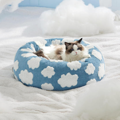 Gato descansando cómodamente en cama donut antiestrés azul